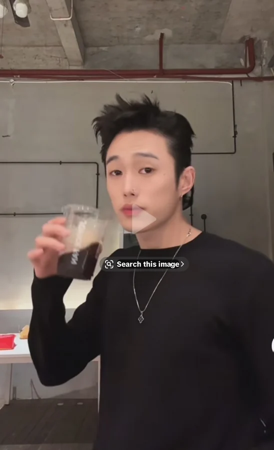six9nie wearing a black shirt and silver necklace